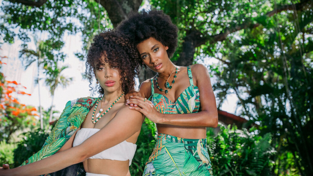 Photo of models wearing conch pearl and emerald jewelry by Emeralds International LLC.