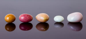 A variety of conch pearl colors, shapes and sizes in a line.