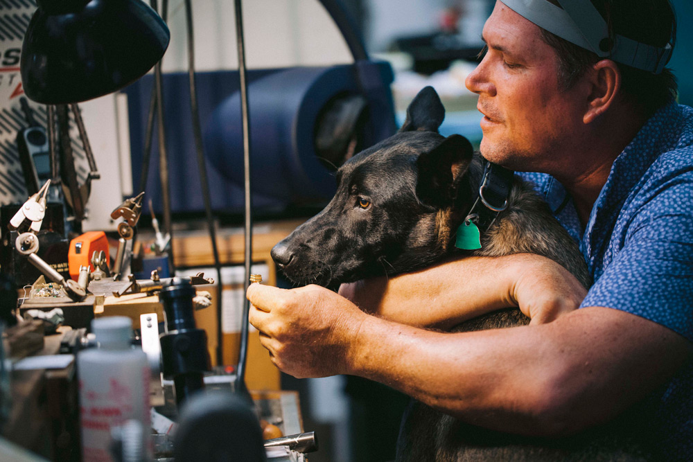 Jeweler and his dog checking a ring setting.