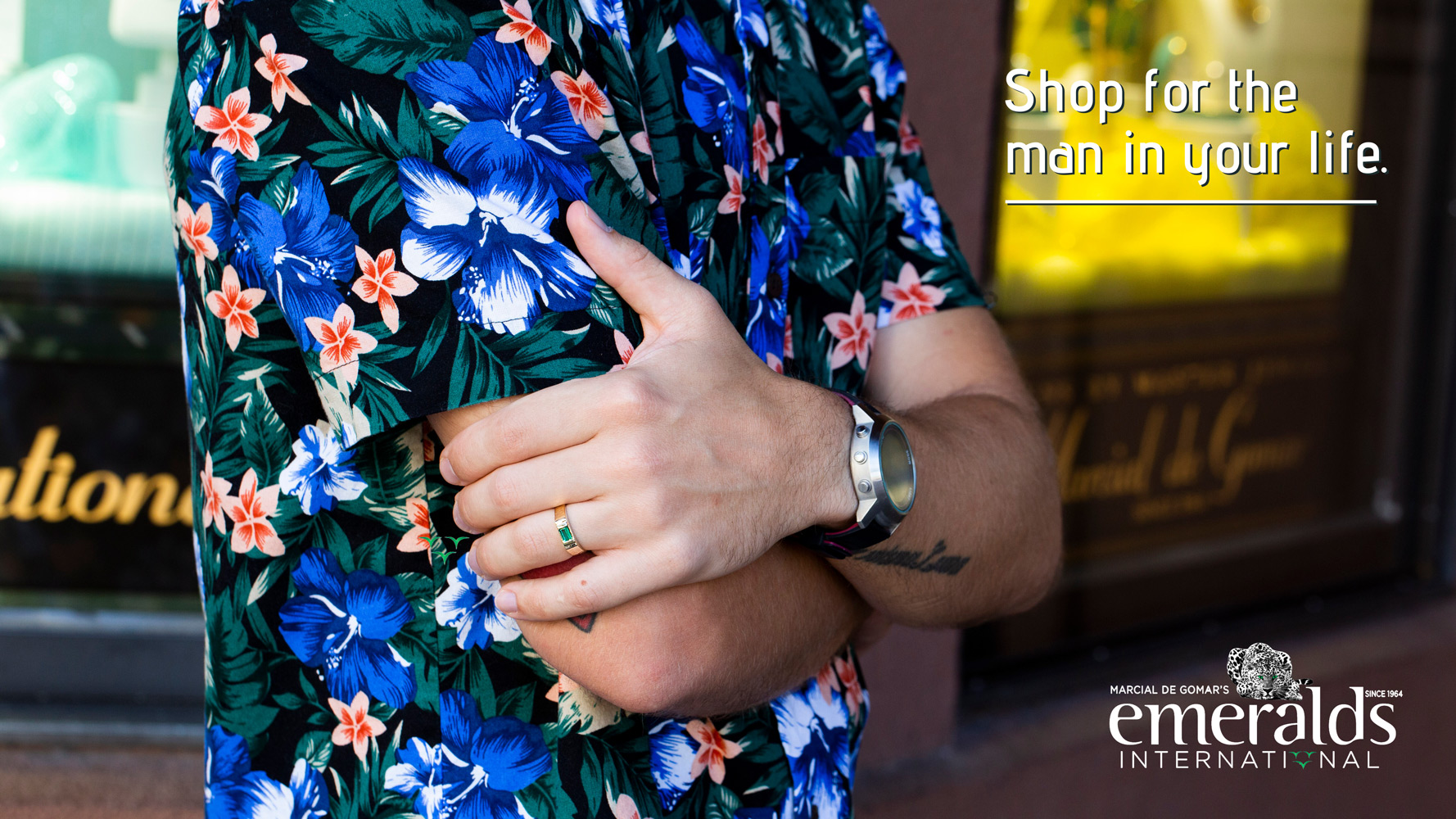 Photo of a man in a hawaiian flower shirt with an emerald ring.