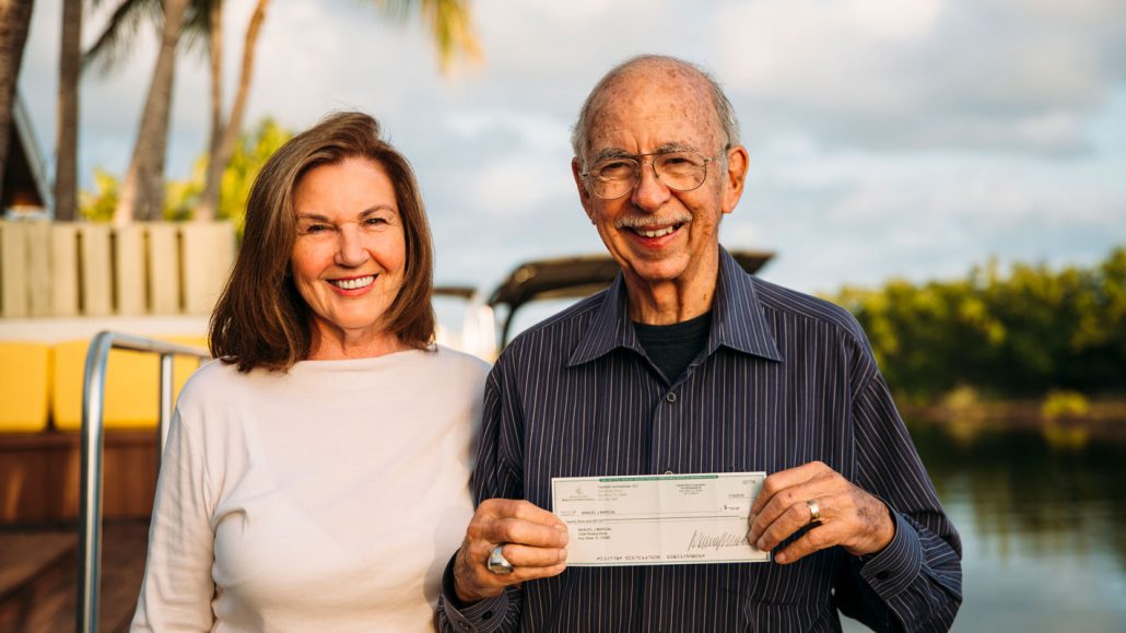 Inge and Manuel Marcial holding a check from the first sale of the Tears of Fura book by Manuel.