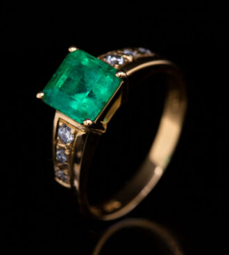 Emerald & Diamond Engagement Ring on a black background.