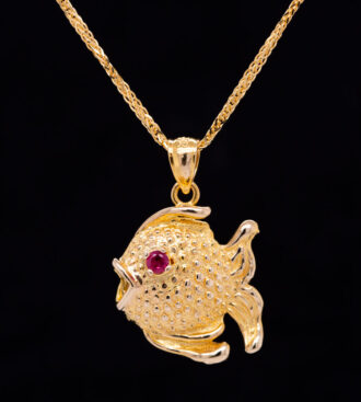 Ruby Baby Puffer Fish Pendant front view on a black background.