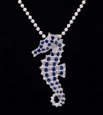Blue Sapphire Seahorse Pendant front view on a black background.