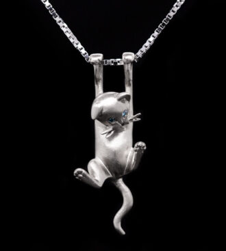 Blue-Eyed Hanging Kitten Pendant front view on a black background.
