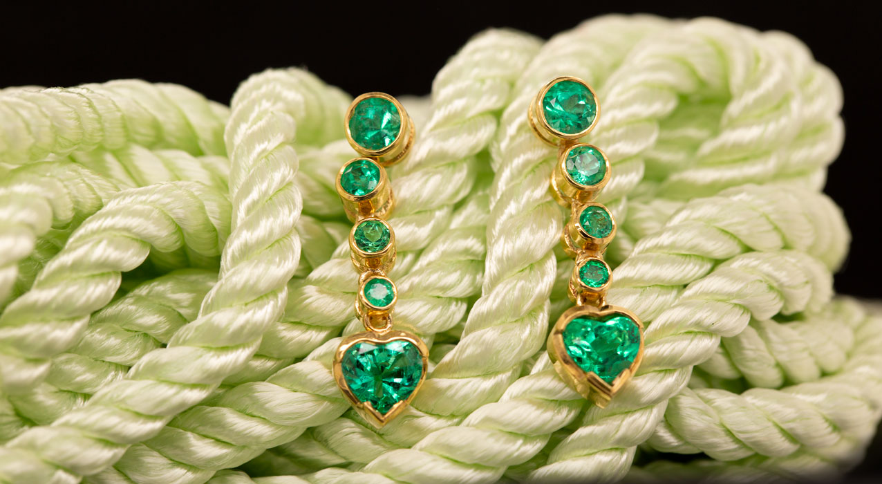 Emerald Heart Drop Earrings nestled in some light green rope.